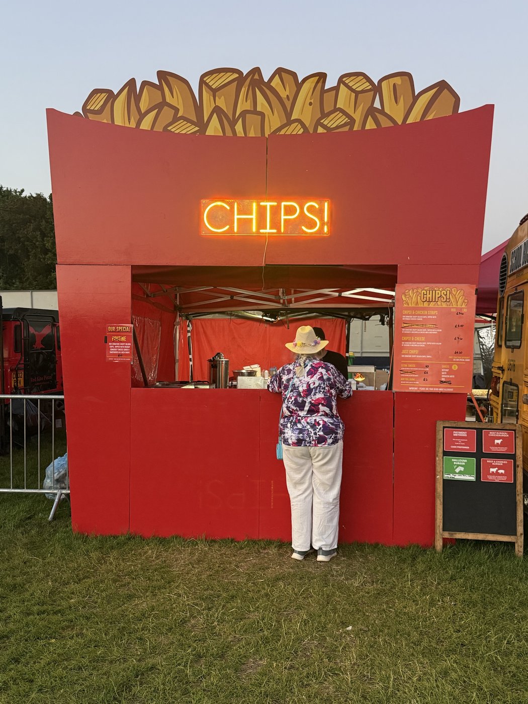 The CHIPS! stall at a festival, with its lit-up neon sign