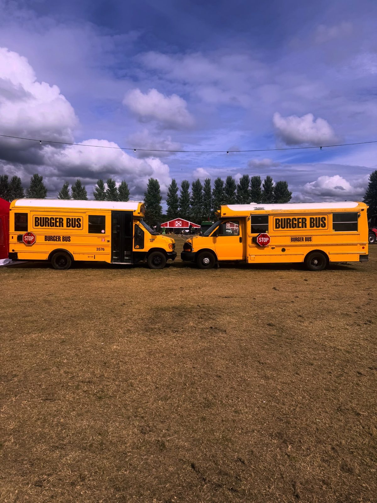Two Burger Bus vehicles parked at an event